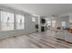 Bright living room with many windows, fireplace, ceiling fan, and contemporary flooring at 5212 Huntley Overlook Dr, Durham, NC 27703