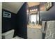 Stylish powder room with sink, mirror, vanity, and dark navy paint at 58 Lake Village Drive Dr, Durham, NC 27713