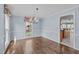 Dining room with hardwood floors, light blue walls, and classic chandelier at 6004 Bramblewood Dr, Raleigh, NC 27612