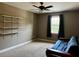 A well-lit bedroom with a ceiling fan and decorative floating shelves on the wall for a simple aesthetic at 61 Langdon Pointe Dr, Garner, NC 27529