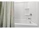 Clean white bathtub and shower combination with curved shower curtain at 6434 Astor Elgin St, Raleigh, NC 27616