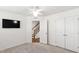 Bright bedroom with a ceiling fan, TV, and stairs in a modern home at 6434 Astor Elgin St, Raleigh, NC 27616