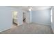 Carpeted light blue bedroom with open bathroom, ceiling fan and closet doors at 6434 Astor Elgin St, Raleigh, NC 27616