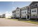Attractive three-story townhomes boast varied neutral colors and manicured lawns in a vibrant community at 6434 Astor Elgin St, Raleigh, NC 27616