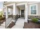 Charming front porch featuring stone accents, black railings, and a decorative wreath on the front door at 6434 Astor Elgin St, Raleigh, NC 27616