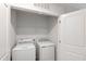 Laundry room with white washer and dryer and wire shelving at 6434 Astor Elgin St, Raleigh, NC 27616