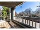 Cozy balcony with wooden floors and railing overlooking a neighborhood street and mature trees, perfect for outdoor relaxation at 700 Bishops Park Dr # 205, Raleigh, NC 27605