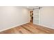 Bedroom with hardwood flooring and view into the kitchen through a sliding barn door at 700 Bishops Park Dr # 205, Raleigh, NC 27605