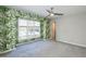 Bright bedroom with large window and gray carpet alongside a vibrant wallpaper featuring a tropical design at 700 Bishops Park Dr # 205, Raleigh, NC 27605