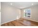 Bright bedroom features a window with blinds and hardwood flooring at 700 Bishops Park Dr # 205, Raleigh, NC 27605