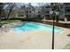 A refreshing community pool surrounded by a brick patio and mature trees at 700 Bishops Park Dr # 205, Raleigh, NC 27605