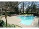 Overhead view of a refreshing community pool, brick patio, and trees at 700 Bishops Park Dr # 205, Raleigh, NC 27605