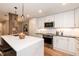 Well-lit kitchen with quartz countertops, stainless steel appliances, and an open design leading to the dining space at 700 Bishops Park Dr # 205, Raleigh, NC 27605
