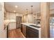 Well-equipped kitchen with stainless appliances, quartz countertops, island with seating, and hardwood flooring at 700 Bishops Park Dr # 205, Raleigh, NC 27605