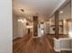 Open-concept living room features hardwood floors, modern lighting, and access to a stylish kitchen with stainless appliances at 700 Bishops Park Dr # 205, Raleigh, NC 27605