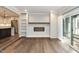 Modern living room with hardwood floors, fireplace, built-in shelves, and kitchen access at 700 Bishops Park Dr # 205, Raleigh, NC 27605