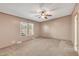 This empty bedroom features neutral carpet, a ceiling fan, and two windows at 71 Oak Trace Dr, Four Oaks, NC 27524