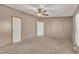This empty bedroom features neutral carpet, a ceiling fan, and two doors at 71 Oak Trace Dr, Four Oaks, NC 27524