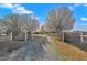 A beautiful gravel driveway leads to the property, framed by blooming trees and a decorative black fence at 71 Oak Trace Dr, Four Oaks, NC 27524