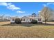 Charming single-story home with a metal roof, manicured shrubs, and a spacious front yard at 71 Oak Trace Dr, Four Oaks, NC 27524