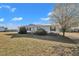 Cozy single-story house with a metal roof, trimmed bushes, and a broad, grassy lawn under a bright sky at 71 Oak Trace Dr, Four Oaks, NC 27524