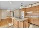 Open-concept kitchen with wood cabinets, an island sink, and adjacent living space filled with sunlight at 71 Oak Trace Dr, Four Oaks, NC 27524