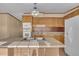 Well-lit kitchen showcasing wood cabinets, a practical center island with a sink, and white appliances at 71 Oak Trace Dr, Four Oaks, NC 27524