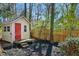 Charming shed with red door set in a backyard with mulch at 7216 Bluffside Ct, Raleigh, NC 27615