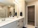 Double vanity bathroom with framed mirror and view into shower and walk-in closet at 730 Firebrick Drive Dr, Cary, NC 27519