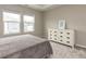 Bedroom featuring two windows, a dresser with black pulls, and neutral decor at 730 Firebrick Drive Dr, Cary, NC 27519