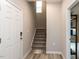 Entryway with wood floors, a staircase leading up, and a view into another room, providing a welcoming entrance at 730 Firebrick Drive Dr, Cary, NC 27519
