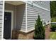Gray front door complemented by brick trim and modern gray horizontal siding at 730 Firebrick Drive Dr, Cary, NC 27519