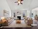 Bright, staged living room with high ceilings, a ceiling fan, and a fireplace at 80 Somerset Dr, Franklinton, NC 27525