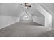 Finished attic featuring carpet flooring, neutral paint, ceiling fans, and natural light at 8201 Southmoor Hill Trl, Wake Forest, NC 27587