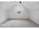 Finished attic showcasing carpet flooring, neutral paint, and a window overlooking trees at 8201 Southmoor Hill Trl, Wake Forest, NC 27587