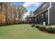 The expansive backyard has lush green grass and mature trees on a cloudy day at 8201 Southmoor Hill Trl, Wake Forest, NC 27587