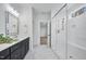 Bright bathroom showcasing a glass shower, walk-in closet, and a black double-sink vanity at 8201 Southmoor Hill Trl, Wake Forest, NC 27587