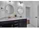 Bright bathroom featuring dual vanities, round mirrors, and a doorway leading to another room at 8201 Southmoor Hill Trl, Wake Forest, NC 27587