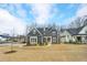 Beautiful home with an expansive front lawn and a classic facade, complemented by mature trees and blue skies at 8201 Southmoor Hill Trl, Wake Forest, NC 27587