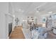 Open concept living room with fireplace, hardwood floors, white trim, and view into the modern kitchen at 8201 Southmoor Hill Trl, Wake Forest, NC 27587