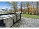 Outdoor kitchen with stone surround, stainless steel appliances, and concrete paver patio at 8201 Southmoor Hill Trl, Wake Forest, NC 27587