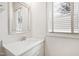 Bright bathroom featuring a white vanity with quartz countertop, framed mirror, and a window with natural light at 909 Lake Boone Trl, Raleigh, NC 27607