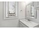 Neat bathroom featuring white vanity with granite countertop, decorative mirror, and a window, providing functionality at 909 Lake Boone Trl, Raleigh, NC 27607