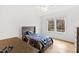 Bright bedroom with hardwood floors, large window, and a cozy bed with a colorful quilt; includes a desk at 909 Lake Boone Trl, Raleigh, NC 27607