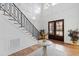 Bright foyer boasts hardwood floors, staircase with decorative railing, and elegant double doors at 909 Lake Boone Trl, Raleigh, NC 27607