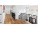 Bright hallway with hardwood floors, iron railing and natural light at 909 Lake Boone Trl, Raleigh, NC 27607