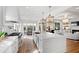 Open-concept kitchen with an oversized island, barstool seating, and modern light fixtures at 909 Lake Boone Trl, Raleigh, NC 27607