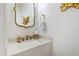 Stylish powder room features a marble countertop and decorative gold fixtures and mirror at 909 Lake Boone Trl, Raleigh, NC 27607