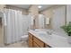 Neutral bathroom with a light wood vanity, white shower curtain, and neutral tile flooring at 9117 Cornwell Dr, Wake Forest, NC 27587
