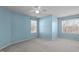 Well-lit bedroom featuring blue walls, neutral carpeting, and two windows with blinds at 9117 Cornwell Dr, Wake Forest, NC 27587